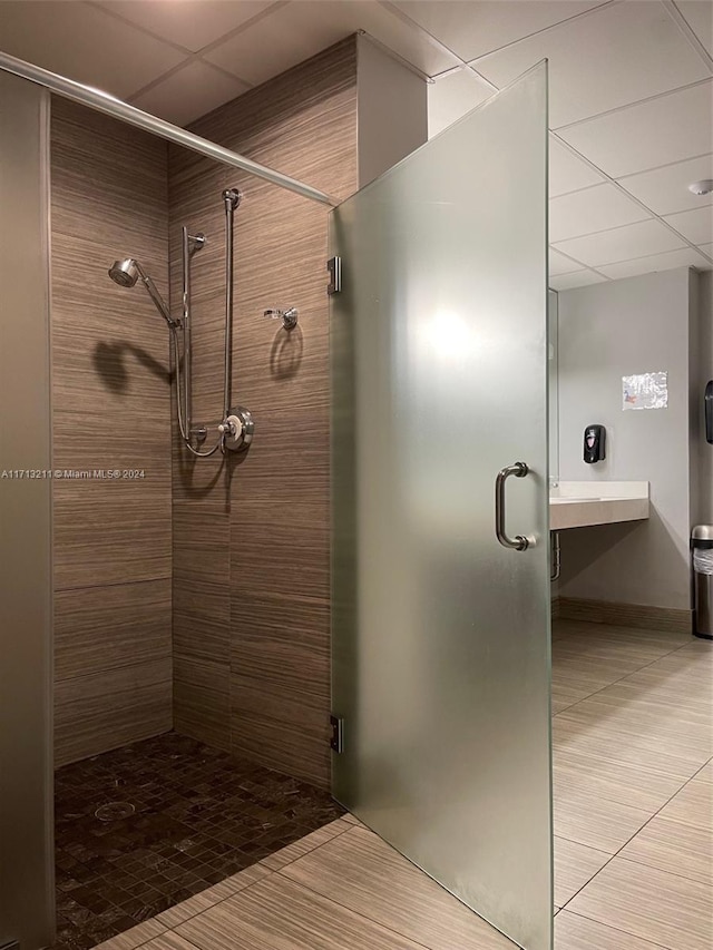 bathroom with tile patterned flooring and a shower with door