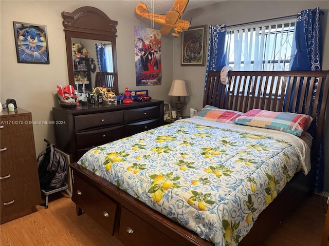 bedroom with light hardwood / wood-style floors and ceiling fan