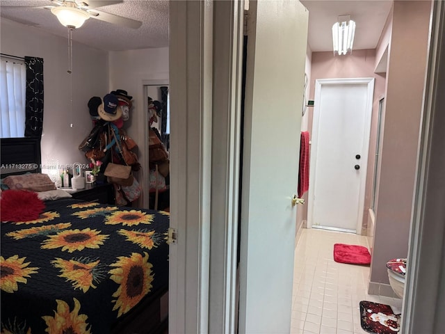 bedroom featuring a textured ceiling, tile patterned floors, and ceiling fan