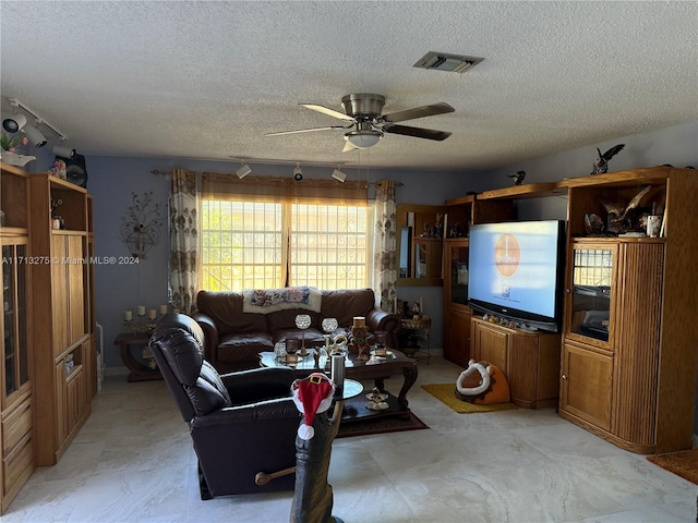 living room featuring ceiling fan, rail lighting, and a textured ceiling