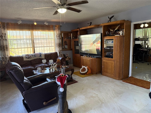 living room with ceiling fan and a textured ceiling