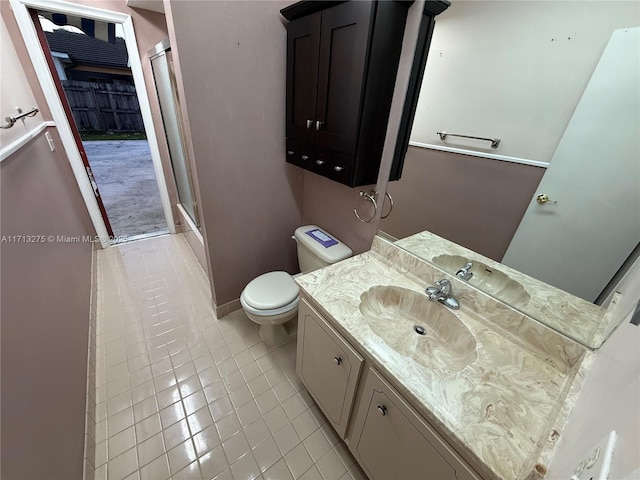 bathroom featuring a shower stall, vanity, tile patterned flooring, and toilet
