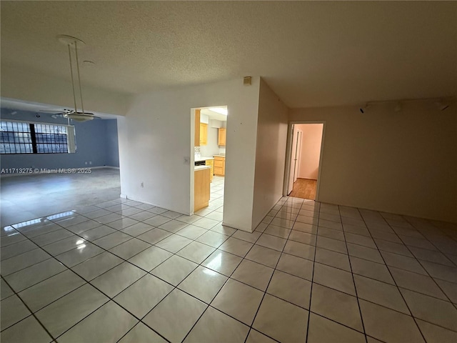 unfurnished room featuring a textured ceiling and light tile patterned floors