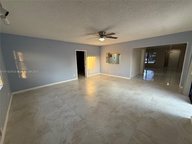 unfurnished room featuring a textured ceiling, baseboards, and a ceiling fan