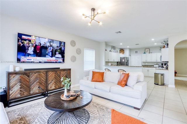 tiled living room featuring an inviting chandelier