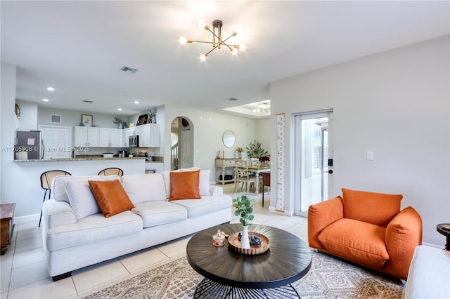 tiled living room with an inviting chandelier