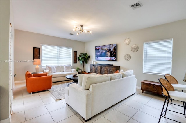 tiled living room featuring a chandelier