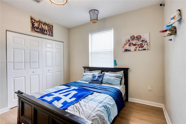 bedroom with light wood-type flooring and a closet