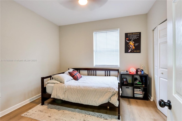 bedroom featuring ceiling fan, a closet, and hardwood / wood-style flooring