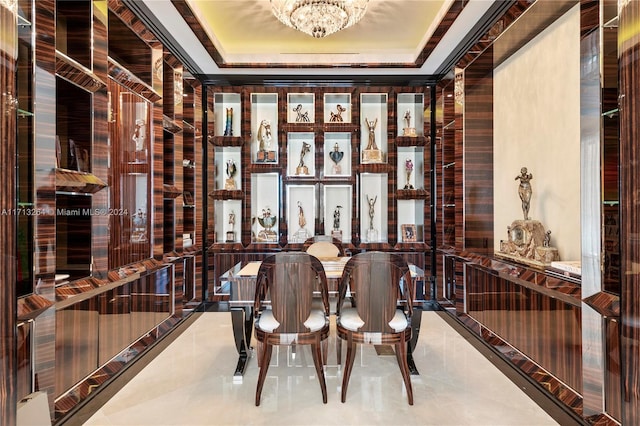 wine area featuring tile patterned floors, an inviting chandelier, and a tray ceiling