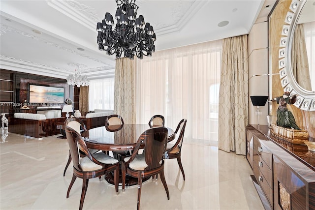 dining area with a tray ceiling, crown molding, and an inviting chandelier