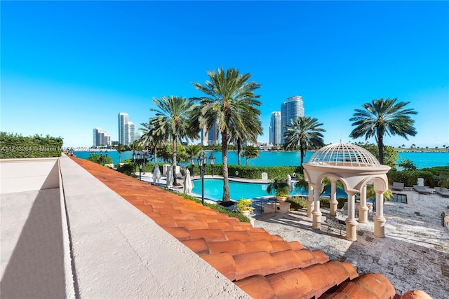 view of swimming pool featuring a patio area and a water view