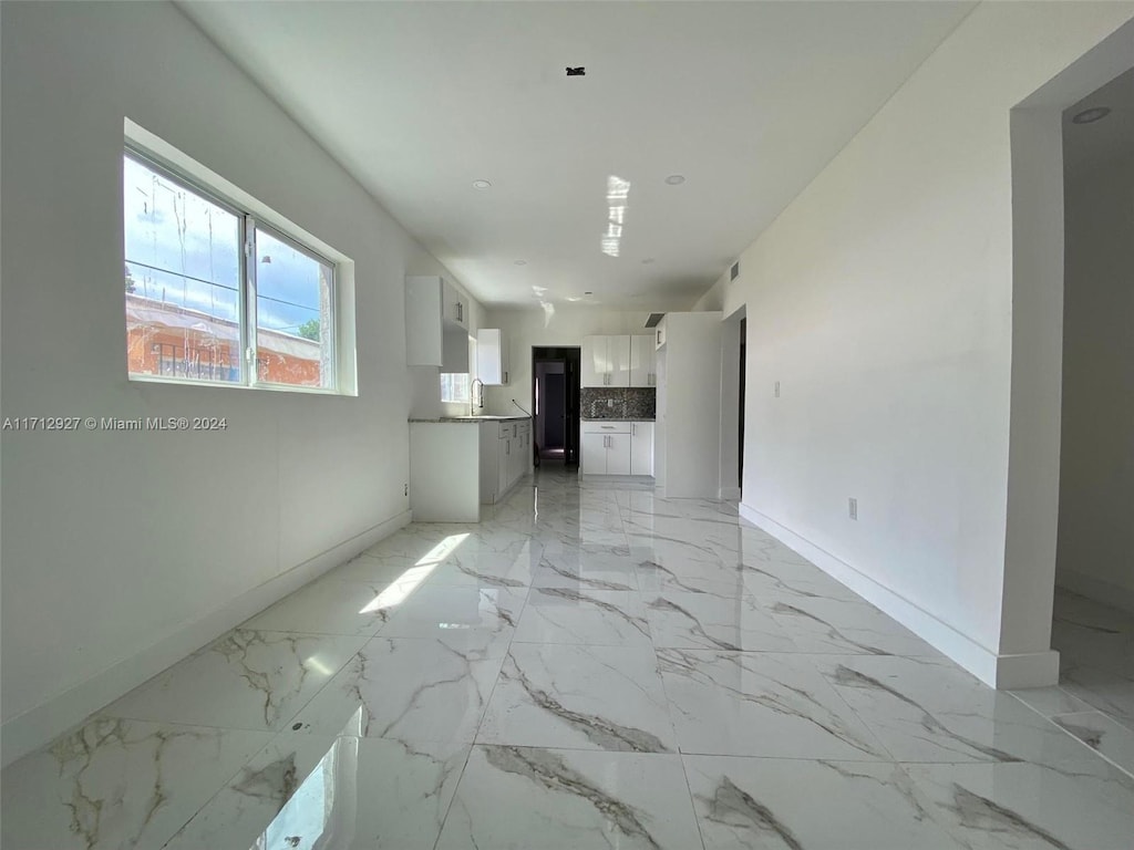 unfurnished living room featuring sink