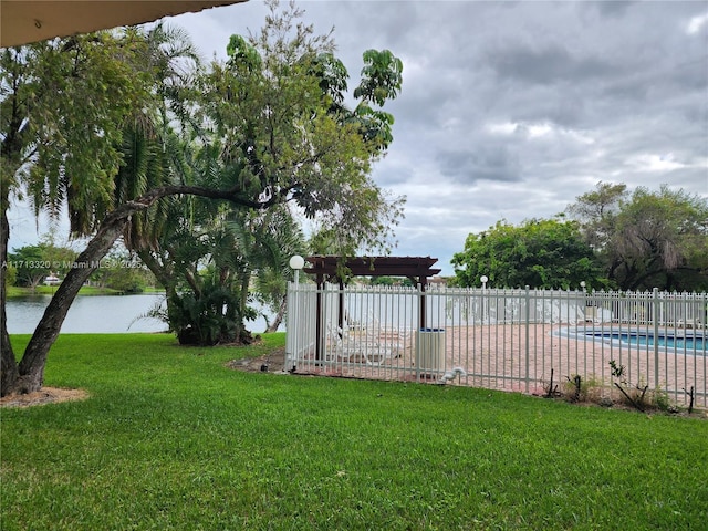 view of yard with a pergola, a water view, and a fenced in pool