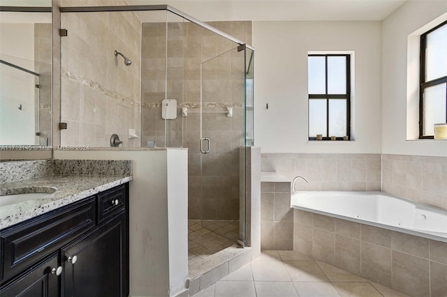 bathroom featuring tile patterned flooring, shower with separate bathtub, and vanity