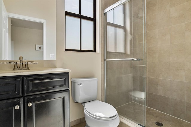 bathroom with vanity, toilet, and a shower with shower door