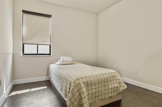 bedroom with dark hardwood / wood-style floors