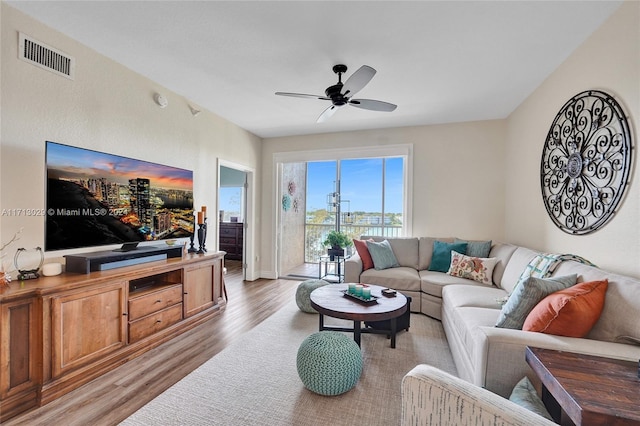 living room featuring light hardwood / wood-style floors and ceiling fan