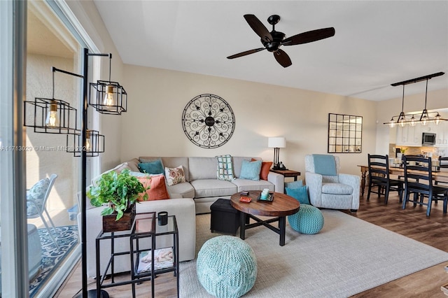 living room featuring wood-type flooring and ceiling fan