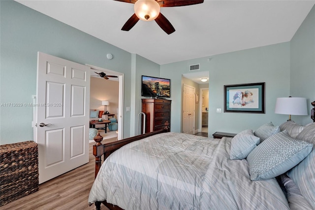 bedroom with ceiling fan, ensuite bathroom, and light hardwood / wood-style floors