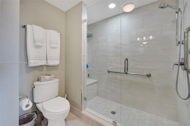 bathroom featuring a shower with shower door and toilet