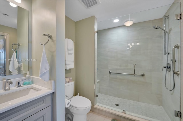 bathroom with tile patterned flooring, vanity, toilet, and walk in shower