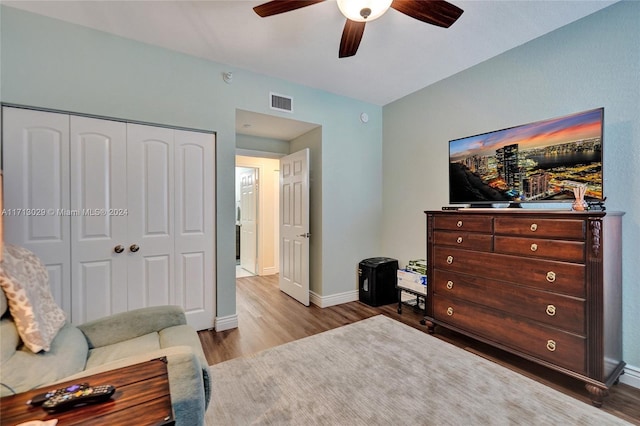 bedroom featuring ceiling fan, light hardwood / wood-style flooring, and a closet