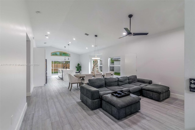 living room with light hardwood / wood-style floors, ceiling fan, and lofted ceiling