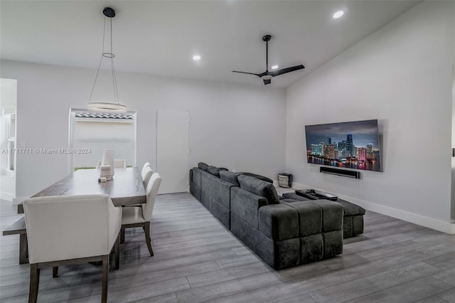 living room featuring hardwood / wood-style floors, ceiling fan, and vaulted ceiling