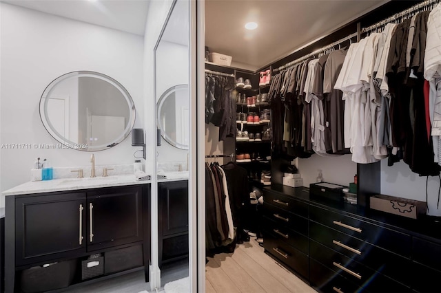 walk in closet featuring sink and light hardwood / wood-style floors