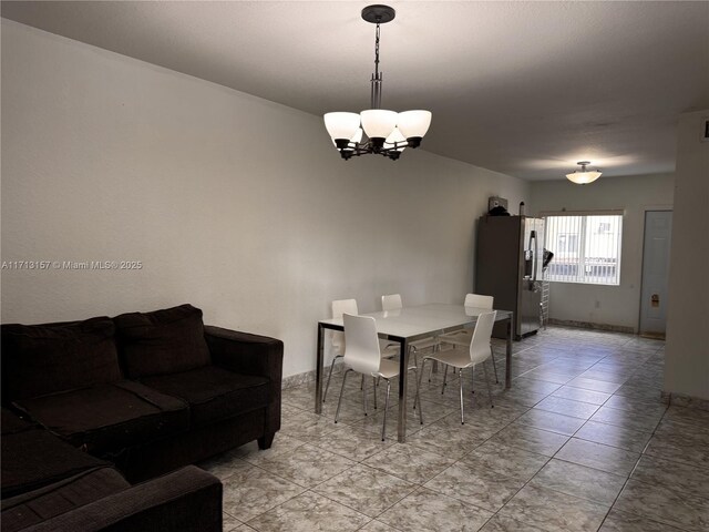 tiled dining room with a chandelier