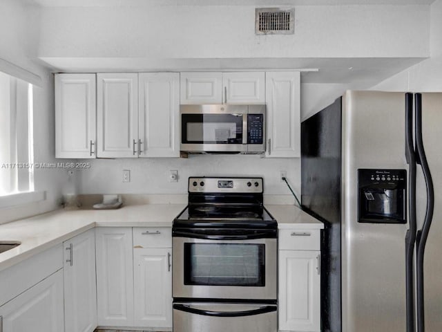 8315 NW 5th Ave Unit 8315, Miami, FL 33150 - kitchen featuring visible vents, light countertops, white cabinetry, and stainless steel appliances