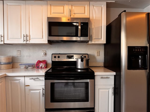 kitchen featuring backsplash, white cabinets, and appliances with stainless steel finishes