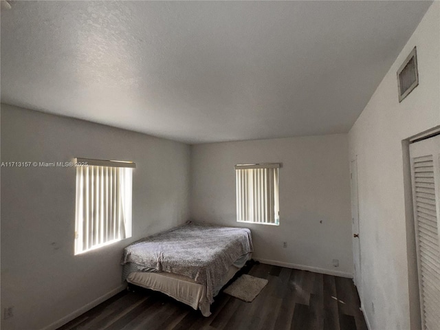 bedroom with dark hardwood / wood-style flooring