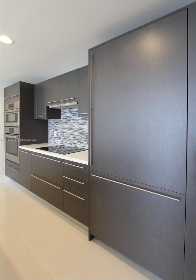 7875 NW 107th Ave Unit 719, Doral, FL 33178 - kitchen featuring double oven, backsplash, black electric stovetop, light countertops, and modern cabinets