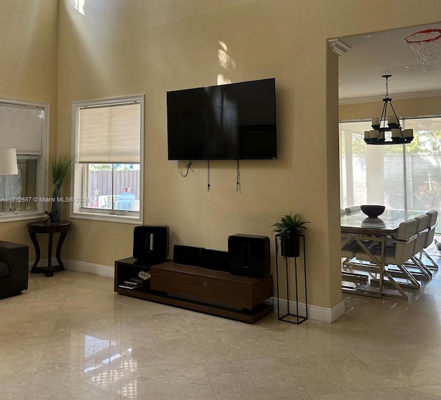 living room with crown molding and an inviting chandelier