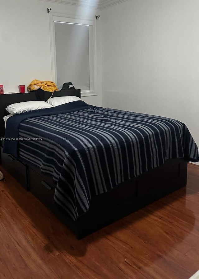 bedroom featuring dark hardwood / wood-style floors and ornamental molding