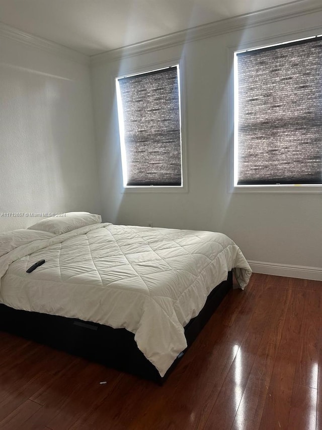 bedroom featuring multiple windows, crown molding, and hardwood / wood-style flooring