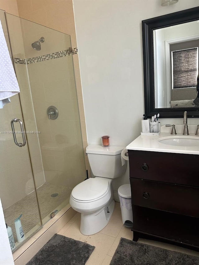 bathroom featuring tile patterned floors, vanity, toilet, and an enclosed shower