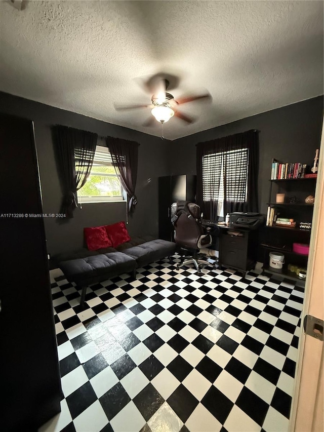 home office featuring ceiling fan and a textured ceiling