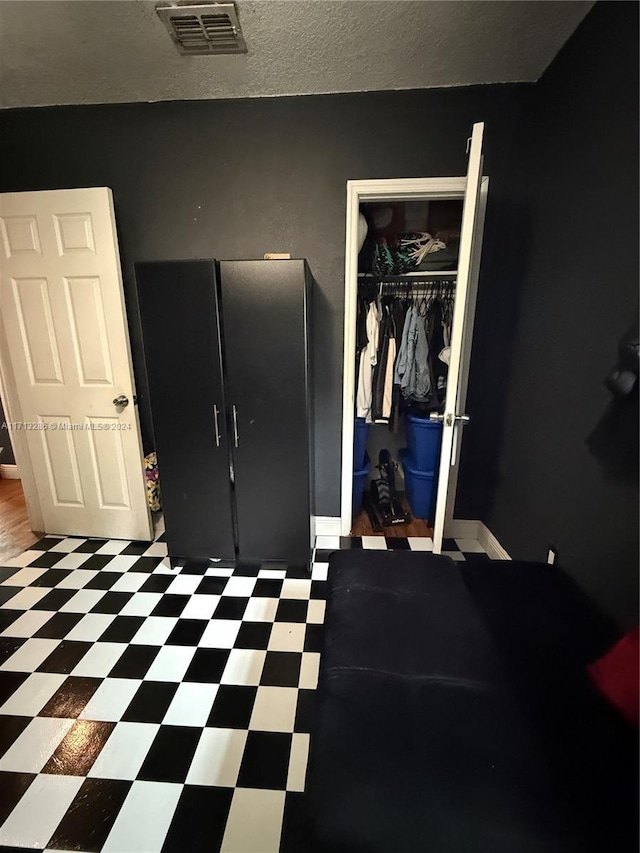 bedroom with a textured ceiling and a closet