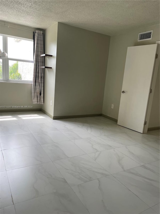 spare room with a textured ceiling