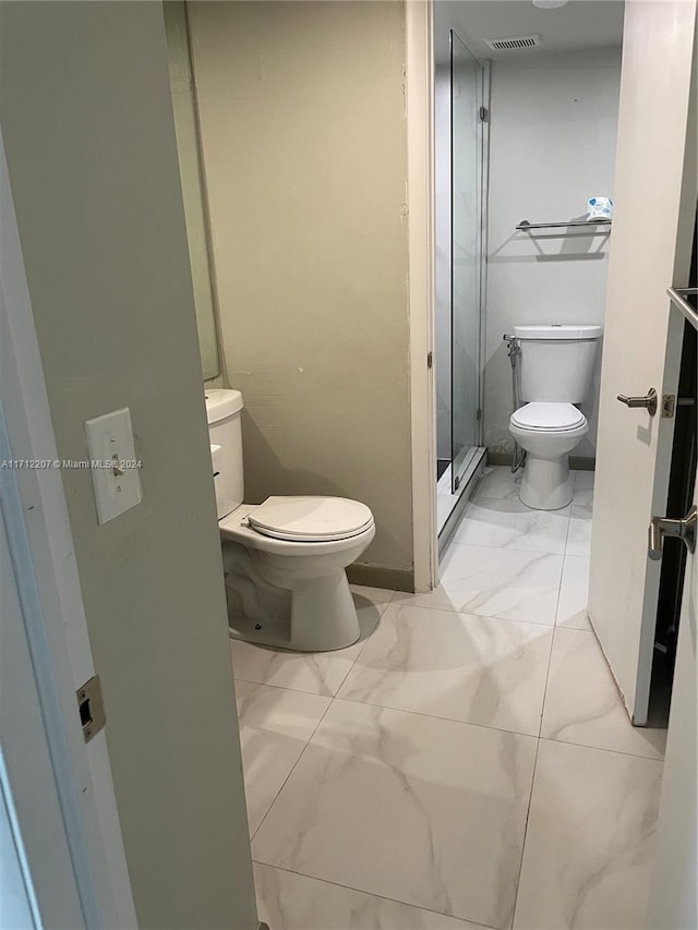 bathroom with toilet and a shower with door