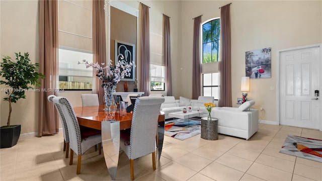 tiled dining space with plenty of natural light and a towering ceiling