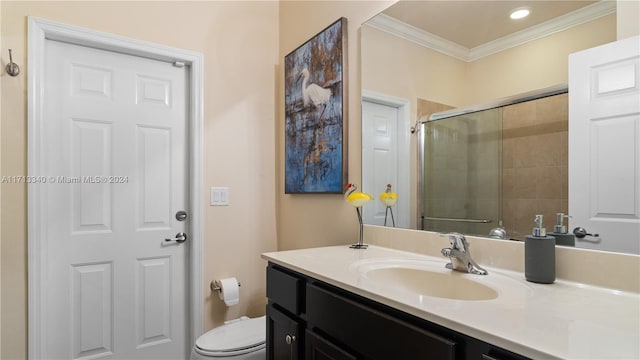 bathroom with vanity, toilet, an enclosed shower, and crown molding