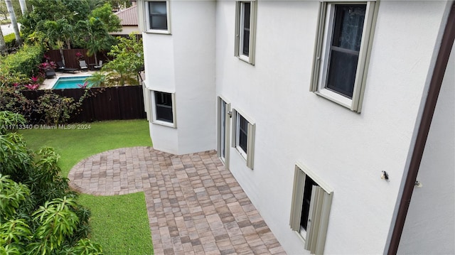 view of side of home featuring a yard and a patio area