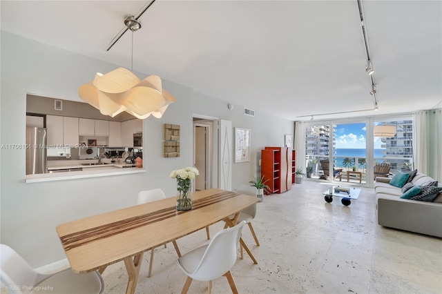 dining room with floor to ceiling windows, sink, and track lighting