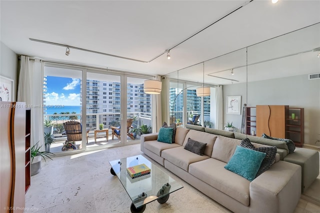 living room with a water view, expansive windows, and rail lighting