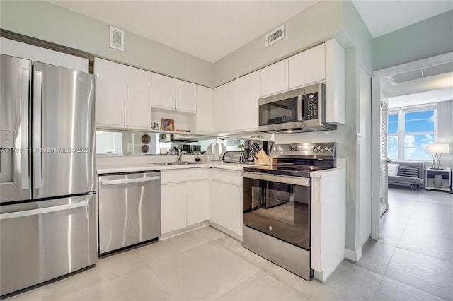 kitchen with stainless steel appliances, white cabinetry, and sink