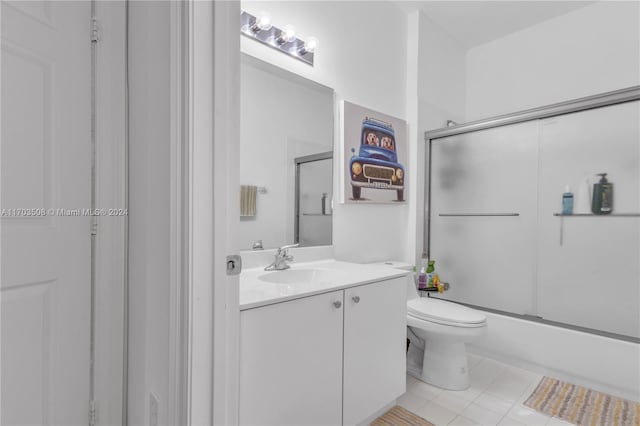 full bathroom with toilet, tile patterned flooring, vanity, and combined bath / shower with glass door